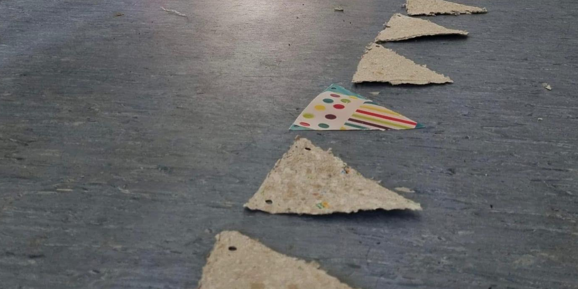 A row of handmade paper triangle bunting pieces