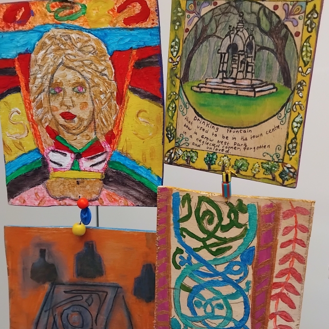 Paintings depicting a stone carved head, drinking fountain and celtic knotwork.